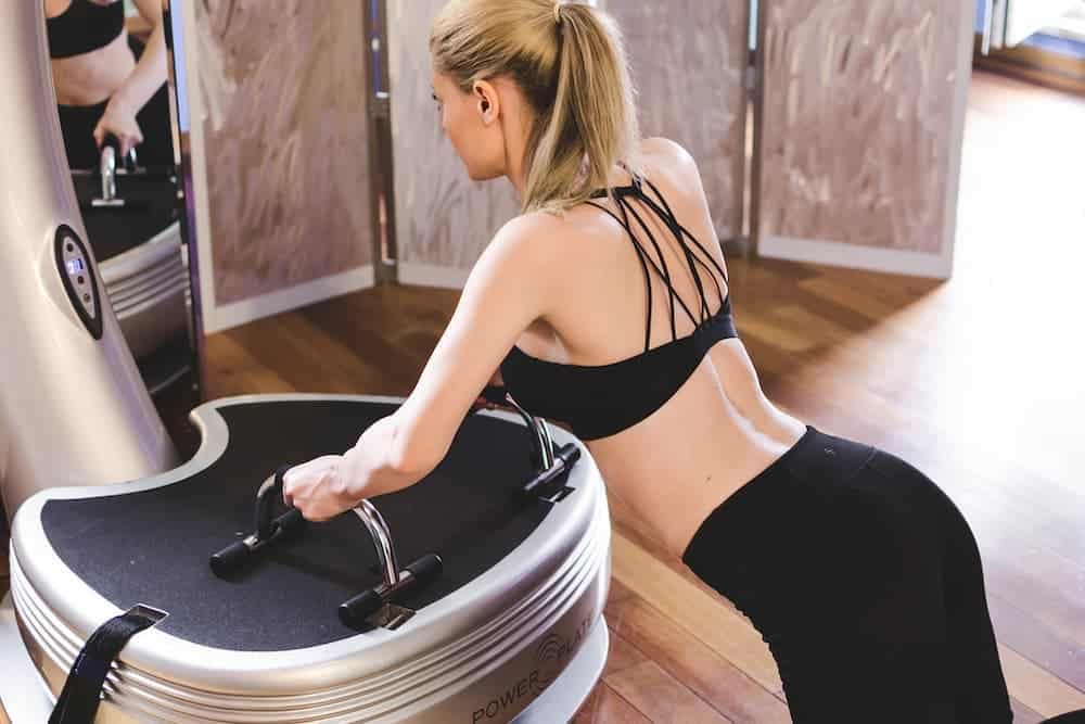 Woman doing push up on vibration machine