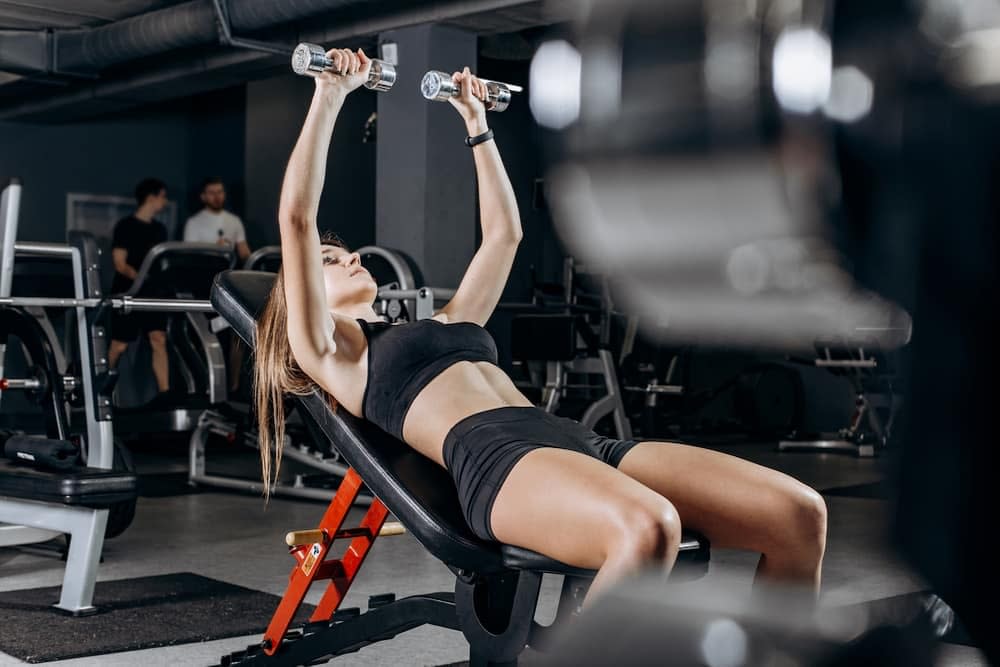 Woman Performing Inclined Dumbbell Bench Press