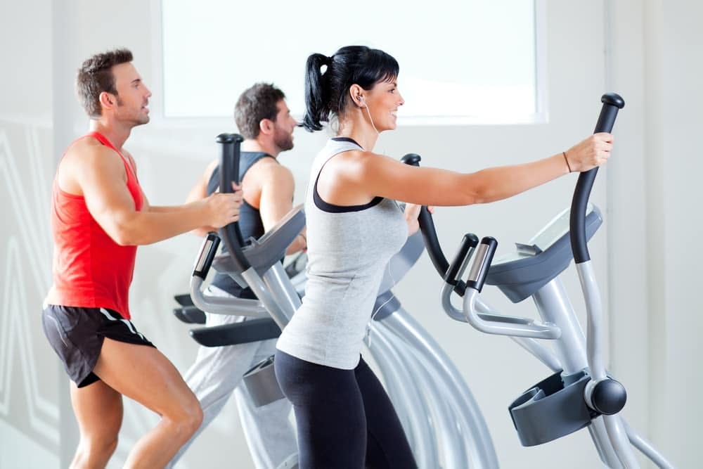 A group of people training on elliptical machines