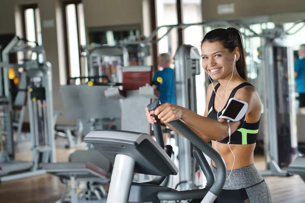 Young girl smiling while exercising on an elliptical machine