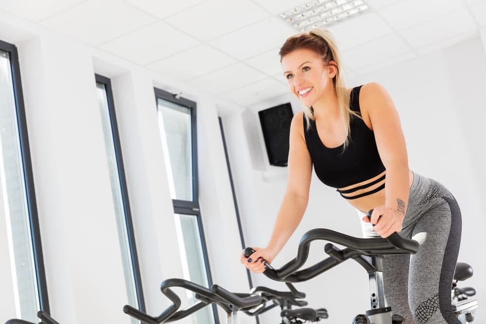 Woman riding an exercise bike with a smile